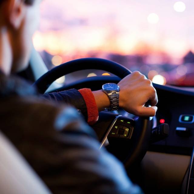 Professional driver behind the wheel of a clean car, illustrating reliable airport transfer and car rental services provided to guests at Panorama Myrtos, Crete.